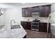 Modern kitchen with granite countertops, stainless steel appliances, and dark wood cabinets at 1632 Lenox Overlook Ne Rd, Brookhaven, GA 30329