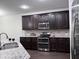 Modern kitchen with granite countertops, stainless steel appliances, and dark wood cabinetry at 1632 Lenox Overlook Ne Rd, Brookhaven, GA 30329