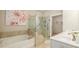 A luxurious bathroom featuring a soaking tub, tiled shower with glass enclosure, and double sink vanity at 2141 Slick Stone Dr, Snellville, GA 30078