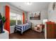 Cozy bedroom featuring a twin bed, accent chair, window with orange curtains, and modern décor at 2141 Slick Stone Dr, Snellville, GA 30078