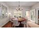 Lovely dining room featuring a modern chandelier, hardwood floors, and access to patio at 2141 Slick Stone Dr, Snellville, GA 30078