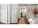 Bright hallway showcasing hardwood floors, neutral paint, and views of the kitchen and living areas at 2141 Slick Stone Dr, Snellville, GA 30078