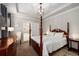 Beautiful main bedroom featuring a tray ceiling, four-poster bed, and ensuite bathroom at 2141 Slick Stone Dr, Snellville, GA 30078