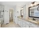 Bright bathroom featuring double vanity with granite counters, framed mirrors, and glass enclosed shower at 3463 Dunbar Ln, Suwanee, GA 30024