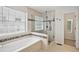 Bathroom showcases a soaking tub next to glass enclosed shower, complemented by decorative tile accents at 3463 Dunbar Ln, Suwanee, GA 30024
