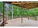 Covered wooden deck surrounded by lush trees and a natural setting at 3463 Dunbar Ln, Suwanee, GA 30024