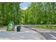 Paved pathway along the Ivy Creek Greenway surrounded by lush green trees on a sunny day at 3463 Dunbar Ln, Suwanee, GA 30024