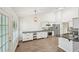 Modern kitchen with stainless steel appliances, white cabinets, and hardwood floors at 3463 Dunbar Ln, Suwanee, GA 30024