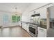 Kitchen with white cabinets, stainless steel appliances and a large window to the backyard and deck at 3463 Dunbar Ln, Suwanee, GA 30024