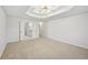 Primary bedroom with a tray ceiling, fan, and ensuite bathroom with double doors at 3463 Dunbar Ln, Suwanee, GA 30024