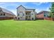 Expansive backyard featuring a well-maintained lawn, privacy fence, and a covered patio for outdoor entertaining at 65 Waters Edge Ln, Covington, GA 30014