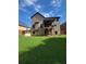 Exterior view of the home's backyard with a lush lawn and a deck on the second story at 65 Waters Edge Ln, Covington, GA 30014