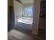 Bright bathroom with a tub under a window and a walk-in closet at 65 Waters Edge Ln, Covington, GA 30014
