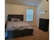 Comfortable bedroom with a paneled bed, natural light, and a dark wood dresser at 65 Waters Edge Ln, Covington, GA 30014