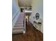 Bright foyer featuring hardwood floors, staircase, and decorative console table adding elegance to the home's entrance at 65 Waters Edge Ln, Covington, GA 30014