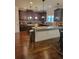 Open-concept kitchen features granite countertops, wooden cabinets, and a convenient island with pendant lighting at 65 Waters Edge Ln, Covington, GA 30014
