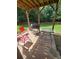 Relax on this backyard patio with a grill, table, and chairs surrounded by a lush green lawn and wooded area at 65 Waters Edge Ln, Covington, GA 30014