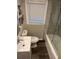 Bathroom featuring a toilet and tub with modern marble-patterned tile and a window at 2148 Meador Se Ave, Atlanta, GA 30315