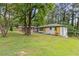 A charming one-story home with a well-manicured lawn and inviting yellow door in a wooded setting at 2148 Meador Se Ave, Atlanta, GA 30315