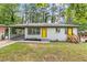 Charming ranch-style home with a bright yellow door, carport, and well-maintained lawn at 2148 Meador Se Ave, Atlanta, GA 30315