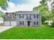 Charming two-story home with grey siding, dark shutters, manicured lawn and an attached two car garage at 3171 Davis Rd, Marietta, GA 30062
