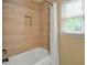 The renovated bathroom features a tile surround, in-wall storage, and modern fixtures at 3171 Davis Rd, Marietta, GA 30062