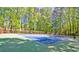 Enjoy a game of tennis on this community court, surrounded by lush trees and a sturdy fence at 3171 Davis Rd, Marietta, GA 30062