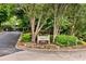 Community entrance sign surrounded by mature landscaping and flowers at 318 Tuxworth Cir, Decatur, GA 30033
