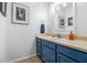 Stylish powder room with blue vanity, neutral countertops, decorative art, and tile flooring at 318 Tuxworth Cir, Decatur, GA 30033