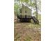 View of the backyard, featuring a wooden deck and stairs surrounded by mature trees, ideal for relaxation at 429 Orchard Dr, Stone Mountain, GA 30083