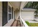 View of the covered porch with wooden floorboards and white railing at 429 Orchard Dr, Stone Mountain, GA 30083
