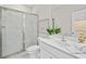 Modern bathroom featuring tiled shower, a marble countertop vanity, contemporary fixtures, and a decorative mirror at 964 Catamaran Ct, Alpharetta, GA 30005