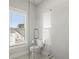 Modern bathroom with a glass shower door, white tiled walls, and a window for natural light at 2005 Haley Walk, Woodstock, GA 30188
