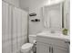Well-lit bathroom with vanity, toilet, shower with gray and white striped curtain, and black floating shelves at 2005 Haley Walk, Woodstock, GA 30188
