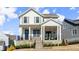 Charming two-story home featuring a welcoming front porch, stone accents, and professionally landscaped yard at 2005 Haley Walk, Woodstock, GA 30188