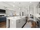 Open-concept kitchen featuring a large island with a sink and stainless steel dishwasher, seamlessly blending to the living room at 2005 Haley Walk, Woodstock, GA 30188