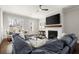 Well-lit living room features a cozy fireplace, a large screen television, and inviting seating arrangements at 2005 Haley Walk, Woodstock, GA 30188