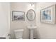 Powder room featuring a pedestal sink, toilet, and decorative wall art at 216 Eping Dr, Stockbridge, GA 30281