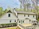 Backyard view of two-story home with painted white brick and siding, and a wooden deck at 313 Summit Ridge Dr, Lawrenceville, GA 30046