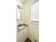 Powder room with modern light fixture, gray marbled vanity, and bright natural light from window at 313 Summit Ridge Dr, Lawrenceville, GA 30046