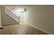 Light-filled living room featuring wood-look floors and white trim, adjacent to a staircase at 313 Summit Ridge Dr, Lawrenceville, GA 30046