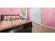 Pink bedroom featuring a bed with floral bedding, side table and natural light at 3492 Newtons Crest Cir, Snellville, GA 30078