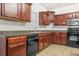 Open concept kitchen with black appliances and wooden cabinets at 3492 Newtons Crest Cir, Snellville, GA 30078