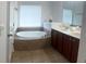 Main bathroom boasts a standalone tub with tile surround and and sinks at 4540 Cold Spring Ct, Cumming, GA 30041