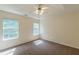 Bright bedroom with a ceiling fan, carpet flooring, and two windows offering natural light at 5680 Hampton Ct, Atlanta, GA 30349