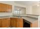 Kitchen featuring wood cabinetry, granite countertops, stainless steel sink, and view into the living area at 5680 Hampton Ct, Atlanta, GA 30349