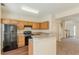 The kitchen features wood cabinets, black appliances, and an open layout to the stairs and entry at 5680 Hampton Ct, Atlanta, GA 30349