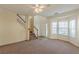 A bright living room with a staircase, neutral carpet, and bay windows for ample natural light at 5680 Hampton Ct, Atlanta, GA 30349