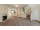 A spacious living room featuring a fireplace, staircase, and an open layout leading to the kitchen at 5680 Hampton Ct, Atlanta, GA 30349