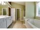 This primary bathroom features neutral paint, double sinks and a separate soaking tub and shower at 2721 Maeve Ct, Dacula, GA 30019